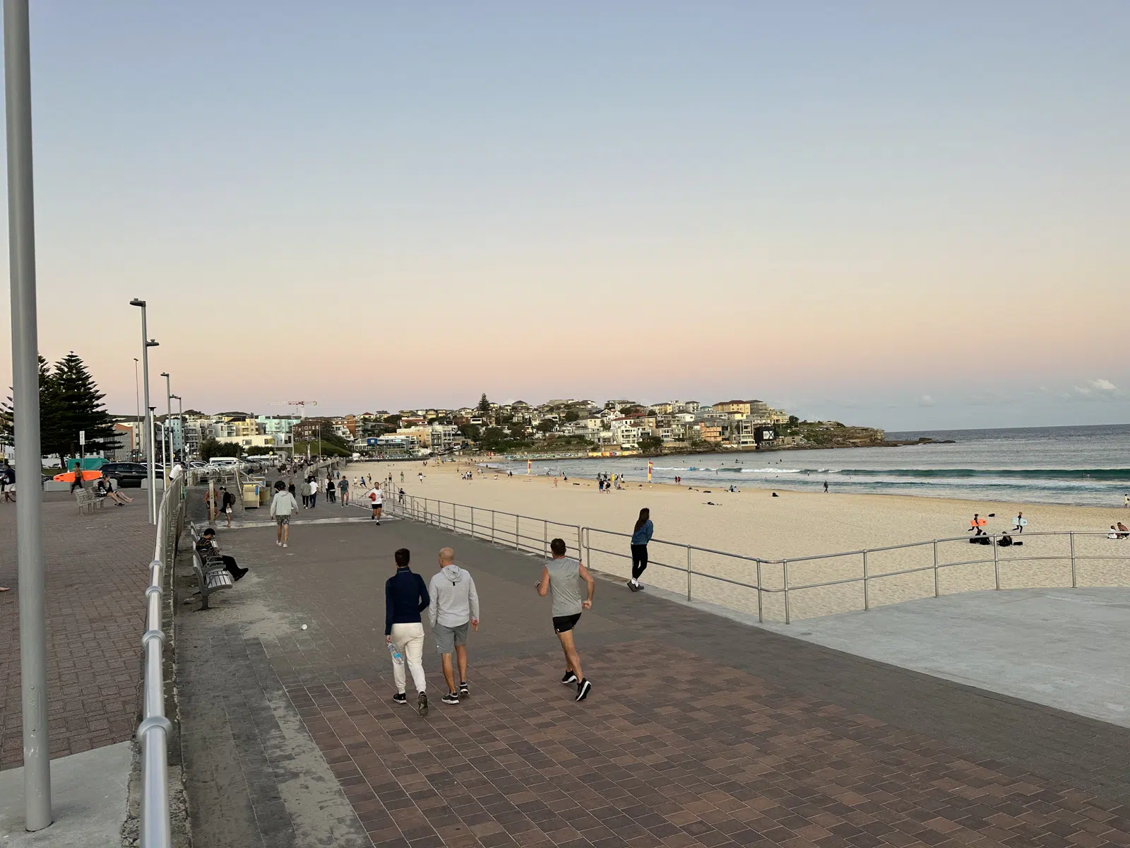 Bondi Beach at evening with people walking along the sand